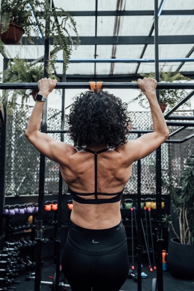 Vrouw pull up kracht krachttraining