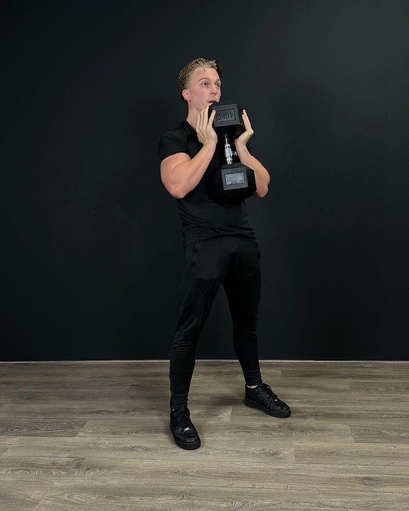 Athlete squatting with a KRAKEN Hex Dumbbell